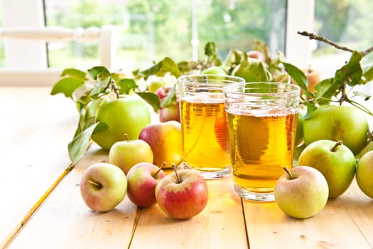 Clear apple juice in glaes with fresh apples