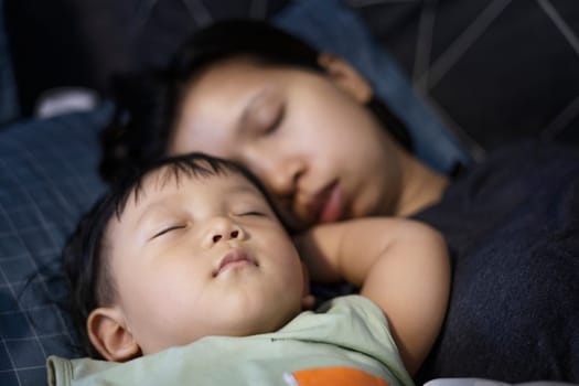 Mother and her baby sleeping in the bed.