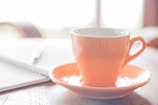 Closeup orange coffee cup in coffee shop, stock photo