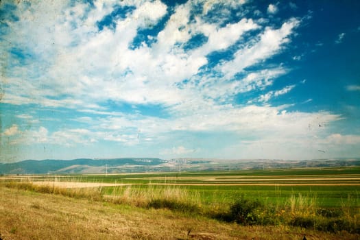 Vintage photo of field and blue sky - rural panoramic landscape