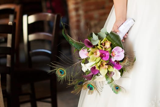 Bride holding beautiful wedding bouquet of orchid and calla