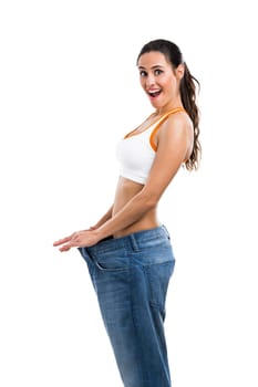Woman with large jeans in dieting concept holding a measuring tape