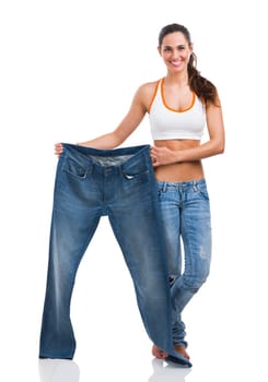 Woman with large jeans in dieting concept holding a measuring tape
