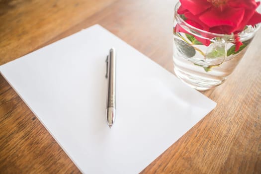 Closeup metal pen on wooden work table, stock photo