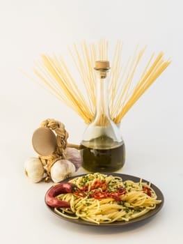 Plate of spaghetti with garlic, olive oil, chili pepper on white background