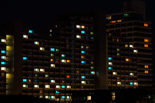 Night colorful windows lights of the high-rise residential building in city sleeping area