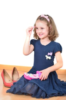 Cute little girl posing while making up