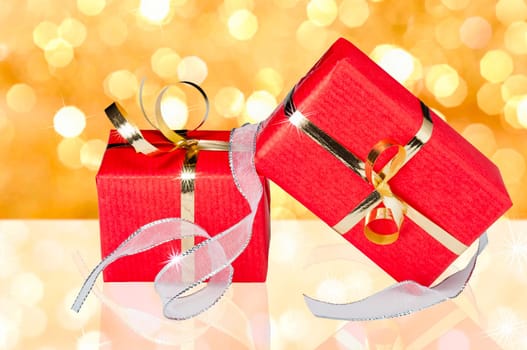 Photo of red and gold gift boxes with out of focus lights on a golden background