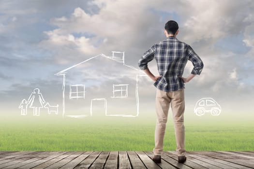 Asian man against the drawing house and family over grassland.