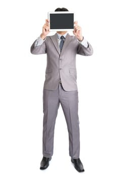 Full body Asian businessman hand holding digital computer tablet covering his face, standing isolated on white background.