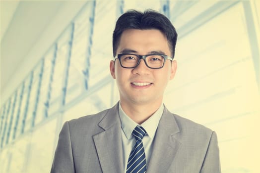 Vintage old style fashion Asian Chinese businessman portrait smiling, office background.