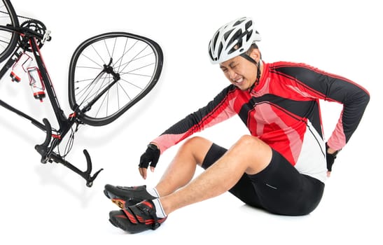 Asian biker fell down from bike, injured at back with painful facial expression, sitting on floor, isolated on white background.