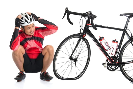 Asian cyclist headache and looking at his flat tire bike, isolated on white background.