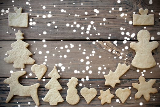 Ginger Bread Cookies as a Frame on Wood with Snow and Copy Space, Christmas or Winter Background with Free Space