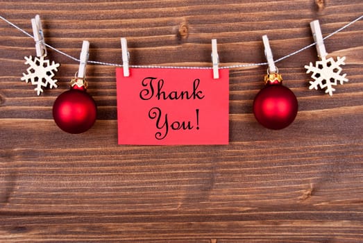 Thank You on a Red Label Hanging on a Line with Christmas or Winter Decoration