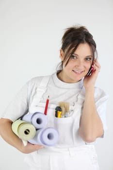 Female decorator holding rolls of wallpaper