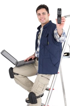 Tradesman posing with his building materials and embracing modern technology