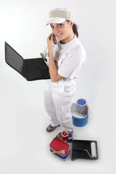 Female painter with laptop and mobile telephone