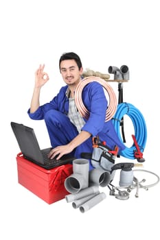 plumber kneeling with computer doing OK sign