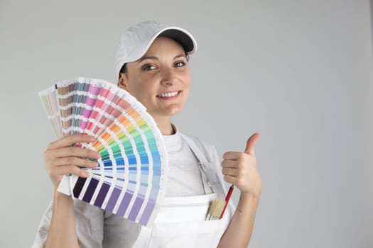 Smiling woman painter holding swatches