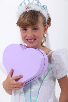 Young girl dressed as a princess and holding a heart-shaped box