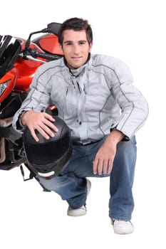 Man kneeling by motor bike