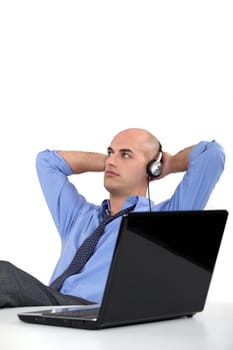 Office worker listening to music through headphones