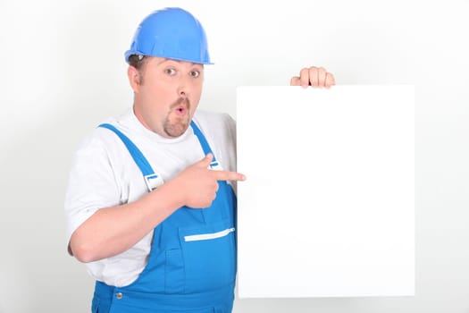 Surprised tradesman holding a blank sign