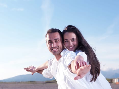 happy young romantic couple in love have fun on beautiful beach at beautiful summer day