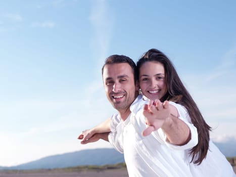 happy young romantic couple in love have fun on beautiful beach at beautiful summer day