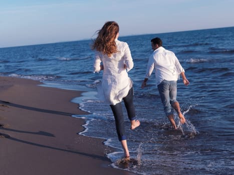 happy young romantic couple in love have fun on beautiful beach at beautiful summer day