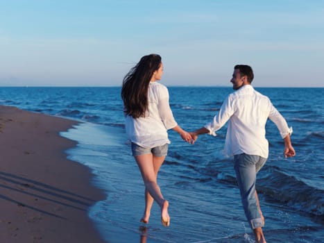 happy young romantic couple in love have fun on beautiful beach at beautiful summer day