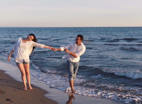 happy young romantic couple in love have fun on beautiful beach at beautiful summer day