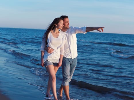 happy young romantic couple in love have fun on beautiful beach at beautiful summer day