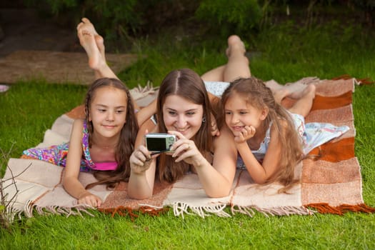 Mother and two daughters making self photo at park