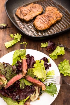Beef sliced on leaf salad in portrait format