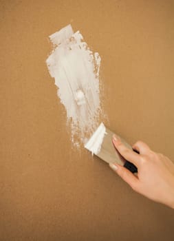 Closeup photo of hand working with spatula and plaster
