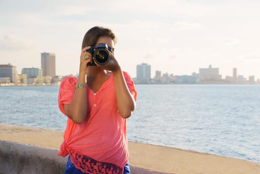 Portrait of young girl in la habana, cuba, taking pictures and photo looking at camera through viewfinder