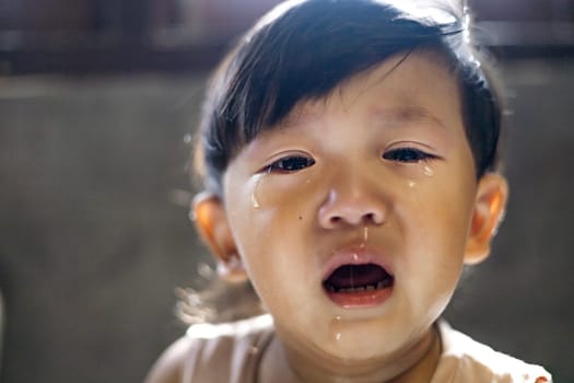 Tears flow from the eyes of boy. Dramatic portrait of a crying boy. The upset child.