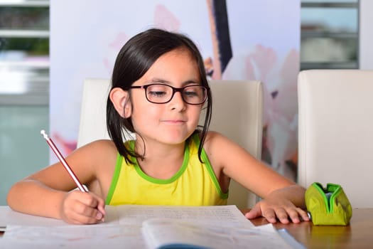 Little cute girl doing homework at home