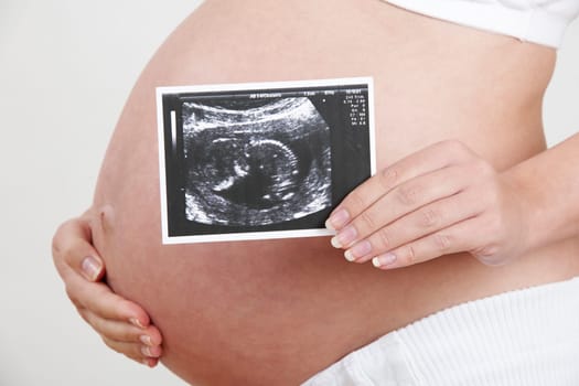 Close Up Of Pregnant Woman Holding Baby Scan