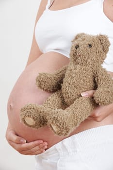 Close Up Of Pregnant Woman Holding Teddy Bear