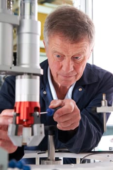 Engineer Working On Machine In Factory