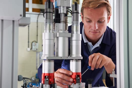 Engineer Working On Machine In Factory
