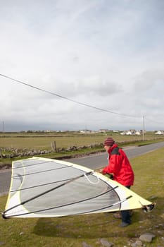 windsurfer getting equipment ready on the beach in the maharees county kerry ireland