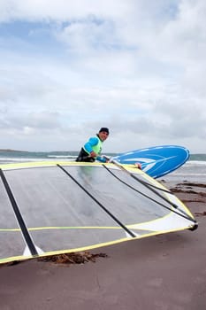 windsurfer getting equipment ready on the beach in the maharees county kerry ireland
