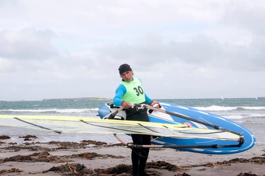 windsurfer getting equipment ready on the beach in the maharees county kerry ireland