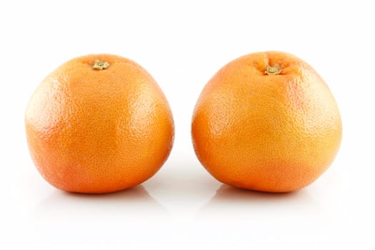 Two Ripe Wet Grapefruits with Leaves Isolated on White Background