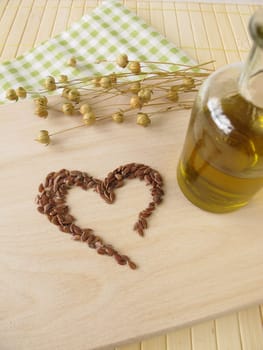 A heart of flaxseed and a bottle of flaxseed oil