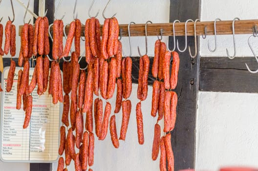 LWL-Open-Air Museum Hagen. Recordings courtesy of the Public Relations Department.. Traditional food. Smoked sausages hang on a pole for sale in a butcher's shop.